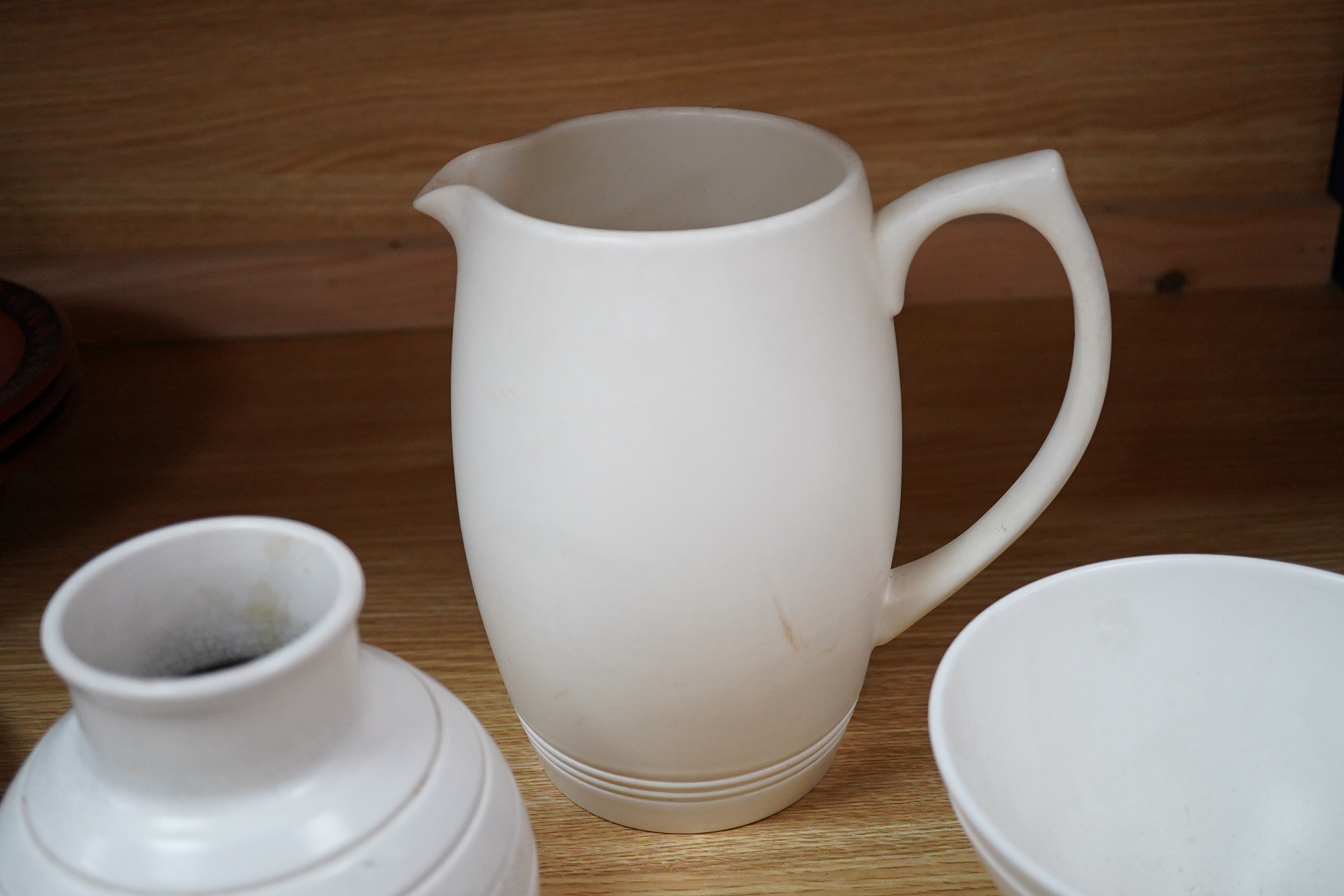 Keith Murray for Wedgwood, moonstone bowl, vase, jug, two mugs, coffee cups and small vase, largest 21cm high